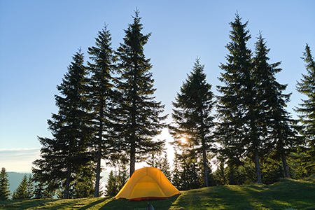 Tourist camping tent on mountain campsite at bright sunny evening