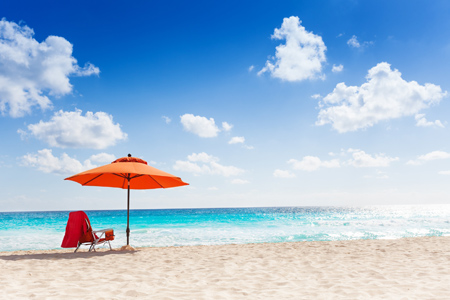 Orange umbrella on the clean beautiful beach and sea panorama with blue sky with couple white clouds