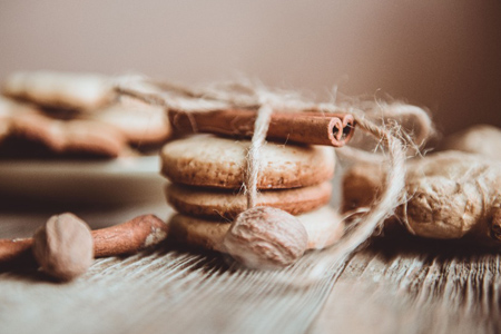 Close up of homemade ginger cookies, cinnamon, ginger on a wooden table. Copy space. Vintage toned i