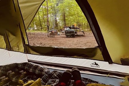 a person lying down in camping tent relaxing