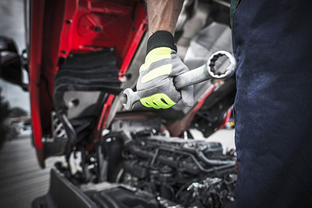 Semi Trucks Mechanic Preparing For the Work. Mechanic with Large Stainless Steel Wrench in Hand.