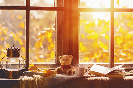 fall. cozy window with autumn leaves, a book, a mug of tea