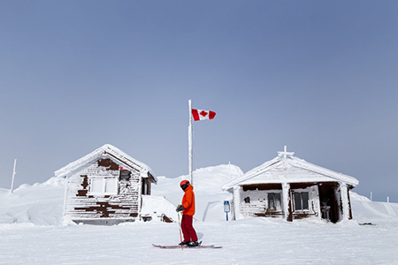 Snow covered mountain hut with a Canadian flag on Whistler Mountain, BC.