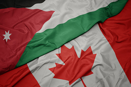 waving colorful flag of canada and national flag of jordan. macro