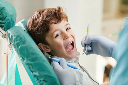 Beautiful child smiling while sitting in the dentists chair. close-up.