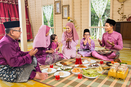 Muslim family praying before meal