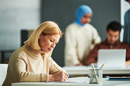 student with pencil giving test while sitting on desk