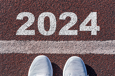 A person shoe on an athletics track engraved with the year 2024