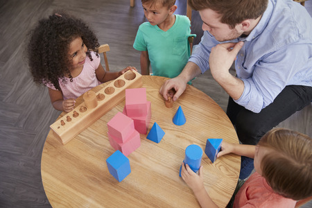 teacher with young kids at table