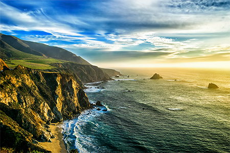 The coastline at Big Sur in california, with steep cliffs and rock stacks in the Pacific Ocean.