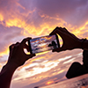 Closeup photo of hands taking a photo from mobile phone. Krabi province, Railay beach on background