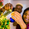 family decorating Christmas tree with ball