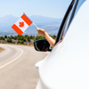 Woman waving flag of Canada from the car window. Travel concept.