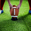 football player preparing for a drop kick on football field