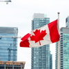 The Canadian flag waving on the background of skyscrapers under construction