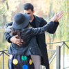 Beautiful dancing couple walking in autumn park near a lake