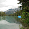 View of water and mountains under cloudy sky - banff