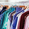 Colorful women's dresses on hangers in a retail shop. Fashion and shopping concept