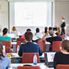 Workshop at university. Rear view of students sitting and listening in lecture hall doing practical 