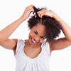 Young african american woman making braids, isolated on white background