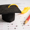 Graduation hat and pencil on answer sheet background