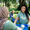 Multiethnic group of volunteers with garbage bags cleaning city park