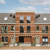 Panorama view of brick houses from an empty sidewalk street with bicycles