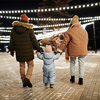 back view of a man and woman spending winter evening with their toddler kid walking