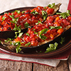 Turkish halves of baked eggplant stuffed with vegetables close-up on a plate. horizontal