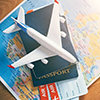 Plane model with world map, passports and tickets as airplane traveling and tickets booking concept