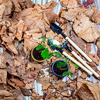 A top view of small pots and gardening tools on dry leaves