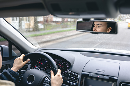 Young cheerful person driving car