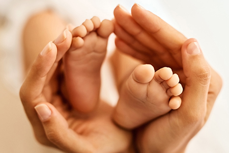 The tiny feet that made her life complete. a mother gently holding her babys feet.