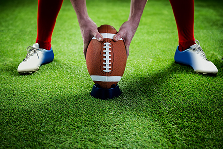 football player preparing for a drop kick on football field