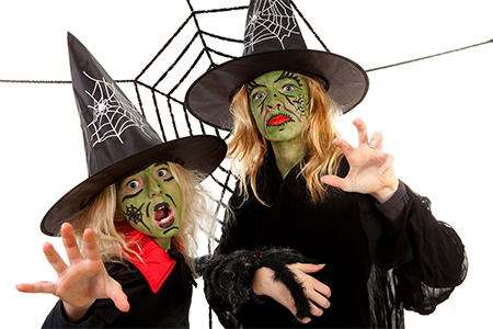 Scary green witches for Halloween with spiderweb over white background