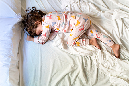 Top view of cute little girl sleeping in bed