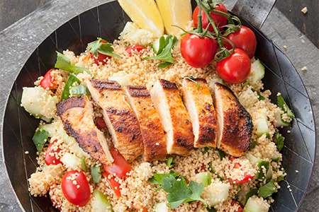 Couscous with grilled chicken breast in iron skillet