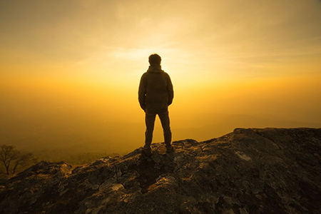 silhouette man standing into sunset sky