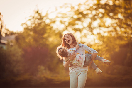 Mother and little daughter playing together in a park