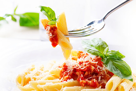 Penne pasta with bolognese sauce, parmesan cheese and basil