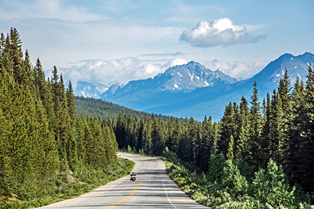 motorcycle on road - rocky mountain in the distance