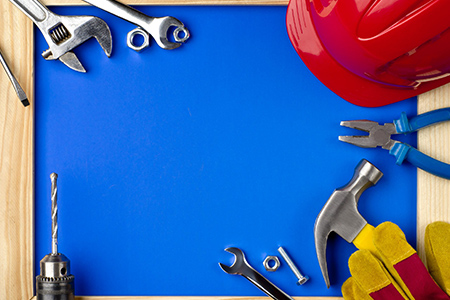 Tools and helmet on a blue background in a wooden frame