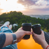 couple laying and enjoying view of sunset over the city. drinking coffee romantic date