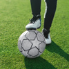 soccer player legs with ball on green grass background, football game