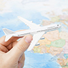 Toy plane in hand with world map on background