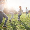 A group of friends in casual outfit play soccer in the open air