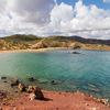 Amazing beach between hills with red sand and emerald sea, island