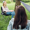 Social distancing. Small group of people enjoying conversation at picnic with social distance in sum