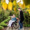Disabled woman in wheelchair with assistant in garden