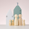 wooden figures of men and a miniature house on a beige background